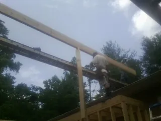Carpenter setting a ridge beam over a new addition frame — Ice Dam Removal by Roofing Brothers in Langeloth