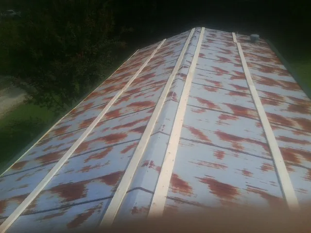 Rusted metal roof panels with new wood purlins before replacement — Storm Damage Roof Repair in Langeloth by Roofing Brothers