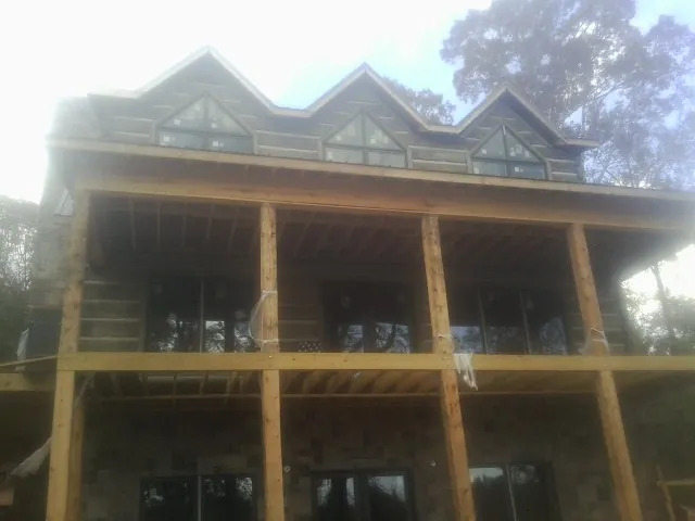 Dormers and porch framing on a large log home under construction — Roof Coating work by our crew in Langeloth