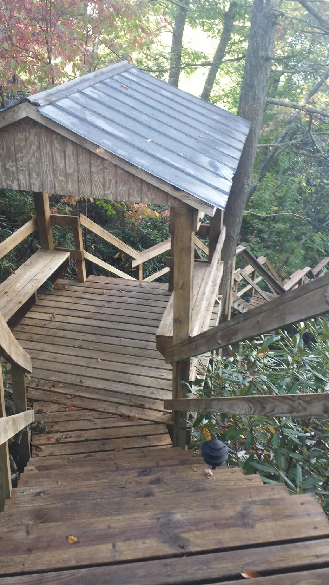 Metal roofed shelter over wooden steps on a wooded walkway — Skylight Repair & Installation work by our crew in Langeloth