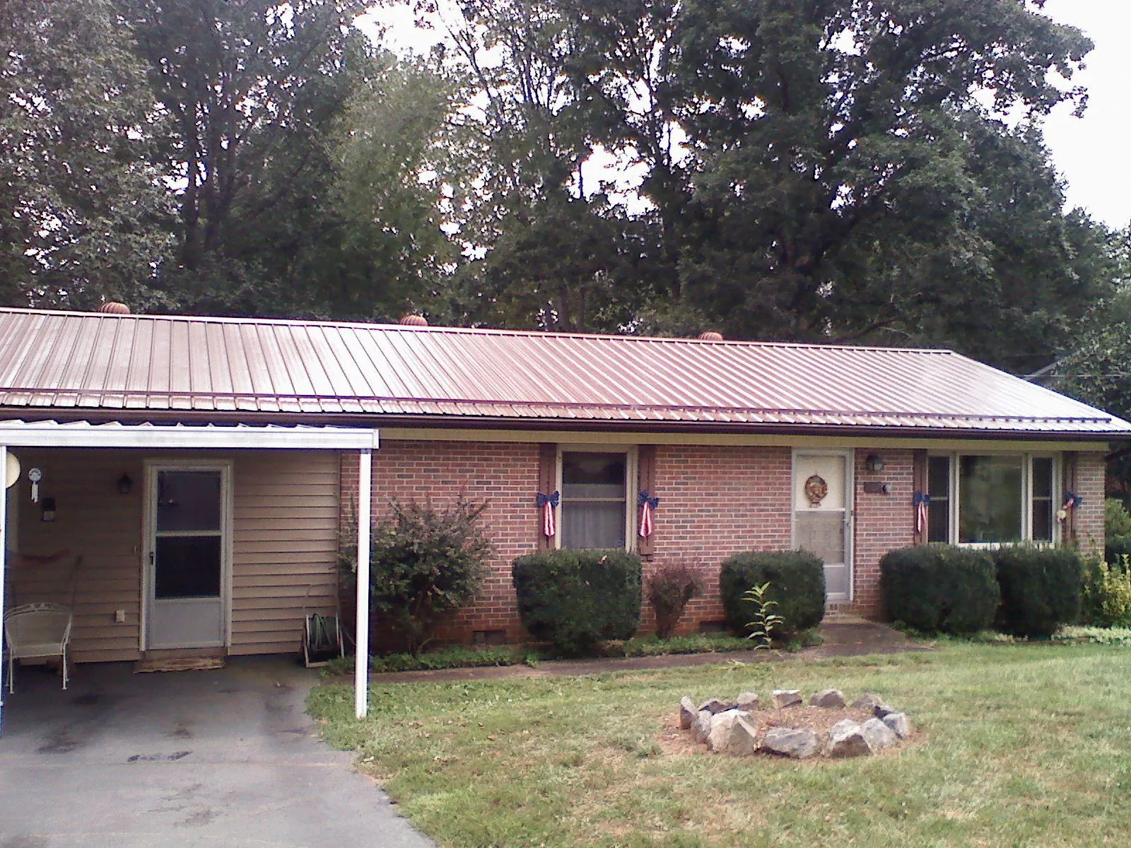 Bronze metal roof and carport on a brick ranch home — Roof Repair work by our crew in Langeloth