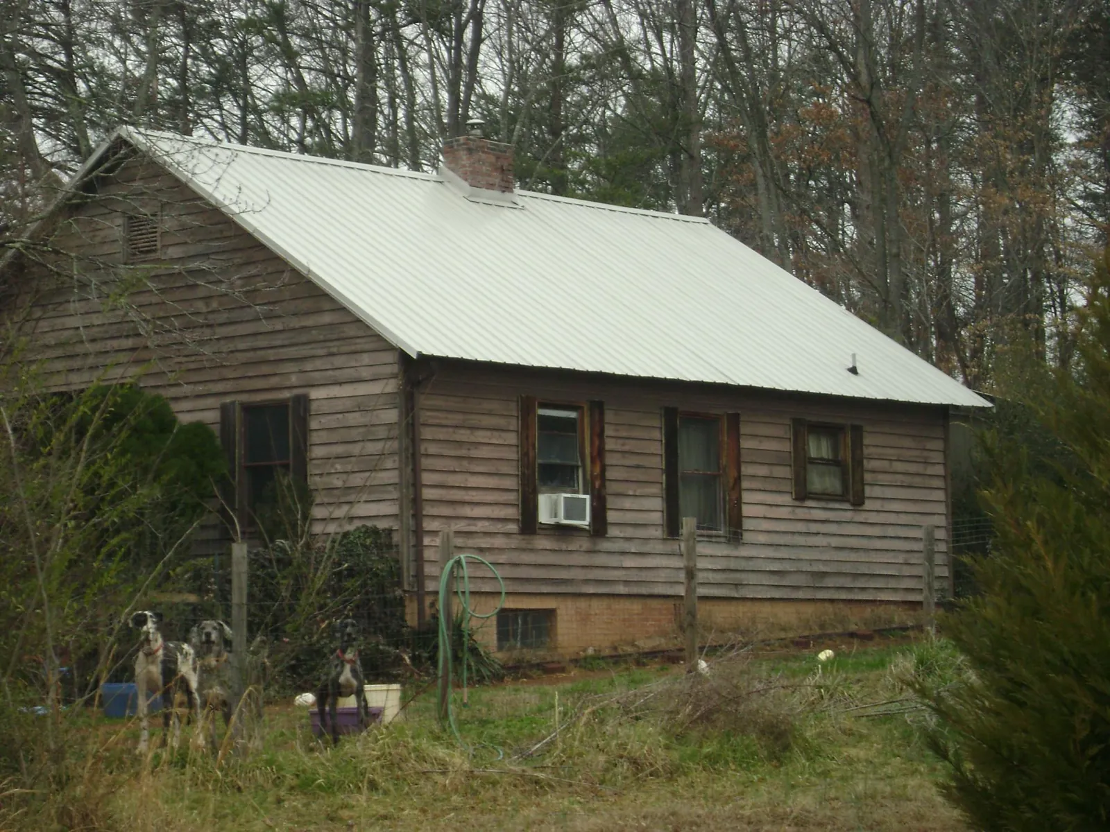 White metal roof on an old wood sided farmhouse, from a Asphalt Shingle Roof Repair job in Langeloth